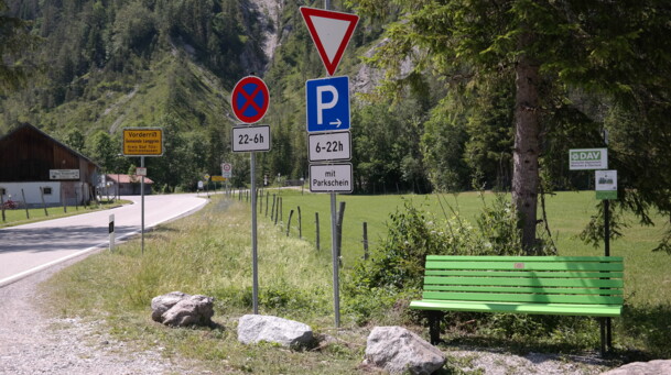 eine grüne Bank an einer Straße
