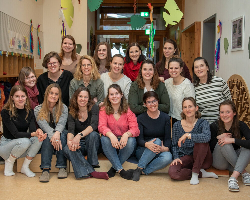 Teamfoto aller Beschäftigten der Kindertageseinrichtung St. Antonius. Das Foto wurde im Innenbereich (Flur) der Kindertageseinrichtung aufgenommen. 